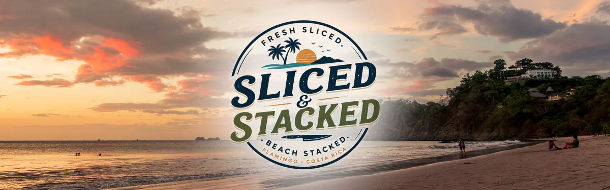 The Sliced & Stacked logo over a photograph of Playa Flamingo at sunset, the sky orange and pink above a long curve of sand with the wooded headland on the right